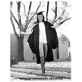 Professional model and Bachelor of Arts graduate Lucy Kiraly on steps near Religious Centre wearing a yellow chamois hot-pants suit.