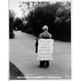 Sandwich board demonstrator, Open Day. 'Are the World's Academic Communities Guilty of Crimes Against Humanity and Other Creatures?'