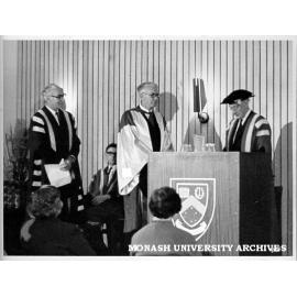 Sir Lindor Brown (centre) receiving honorary Doctor of Science from Chancellor Sir Douglas Menzies, watched by Vice-Chancellor Dr Louis Matheson (left), and Academic Registrar Mr J. D. Butchart (seated)