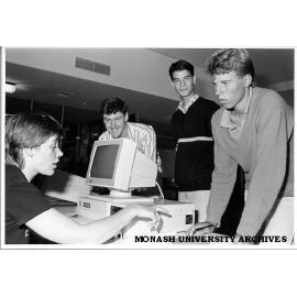 Host Scheme enrolment. Volunteer helper Wendy Bainger (seated) and Coordinator Harvey Kalman (second left) enrolling Peter Smith (right) and Gregory Young