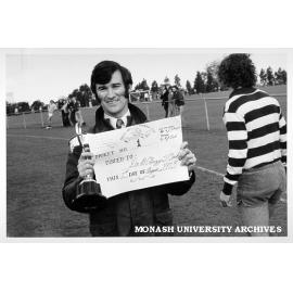 Dr Barry Oakes number one ticket holder for Monash Medicine II football team with CIBA cup presented to Monash captain