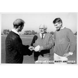 Mr Doug Ellis congratulating rowing team members Justin Negri and Andrew Cohen, on winning Oxford-Cambridge Cup