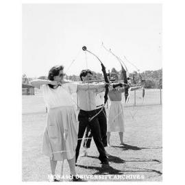 Archery Club members Natalie Tampion, Nick Hatzipantelis, David Maccora [and ?], practising behind Sports and Recreation Centre