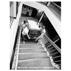 Parts of PABX system being taken up stairs of University Offices