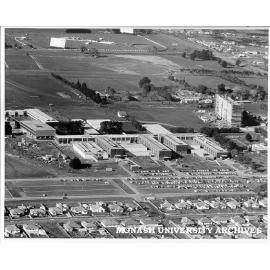 Aerial view of campus buildings, July 1962, from west, with drive-in theatre in background