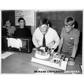 Minister for Science Barry Jones at Science Summer School inspecting solar powered devices designed by Russell Bret (right), Shane McKenzie (far left) and Adam Feldman