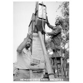 Lecturer Max Murray working on kiln with help of technician Mikhail Nudha