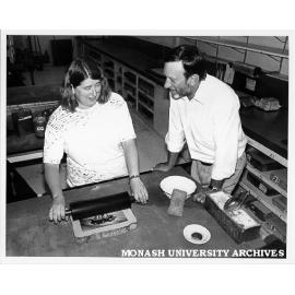 Head of School of Visual Arts Norman Creighton watching lecturer Kaye Green demonstrating art of print lithograph from stone