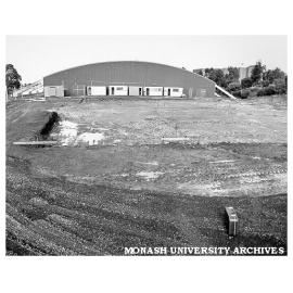 Swimming pool site with sports pavilion in background
