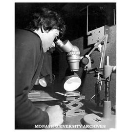 Open Day visitor Paul Henderson examines material under the microscope in Chemical Engineering