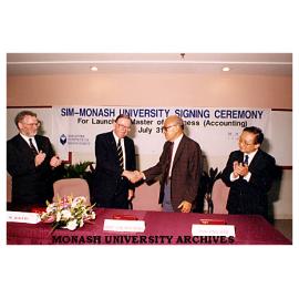 Chancellor Mr Bill Rogers shaking hands with Professor You Poh Seng, executive director Singapoe Institute of Management (SIM). Pro Vice-Chancellor Professor Leo West (left) and SIM executive director Mr Tan Ging Hee applaud