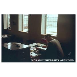 Dr Trevor Hicks at work with Senior Physics building and S5 lecture theatre under construction through window.