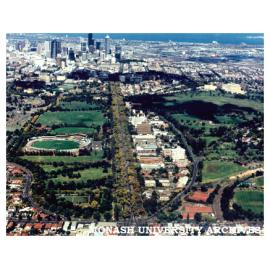 Aerial view of Victorian College of Pharmacy Parkville campus from north down Royal Parade with Optus Oval (Carlton Cricket Ground) on the left and Mebourne CBD in the distance.