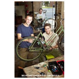 Monash students restoring bikes for sale to students. Mr Tom McKendrick (left) and Mr Ian Adams with Mr Rob Prain in the background.