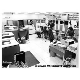 Computer Centre with terminals in front of magnetic tape drive units, Burroughs units and punch cards in box on front desk
