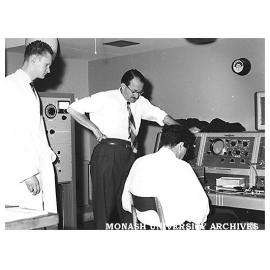 Installing nuclear magnetic resonance spectroscope. Peter Godfrey (left) and Major Tony Bridges.