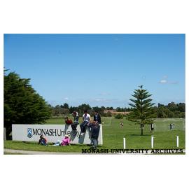 Students by Monash University sign, Berwick campus