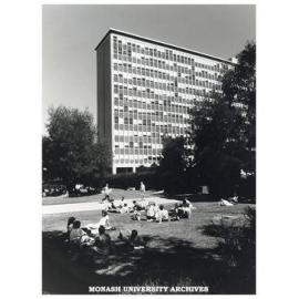 Menzies building and students sitting on lawn in forum